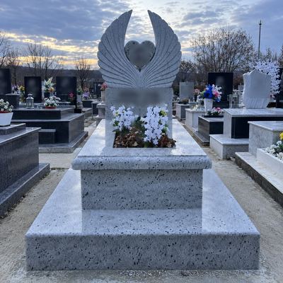 Granite headstone with two carved wings