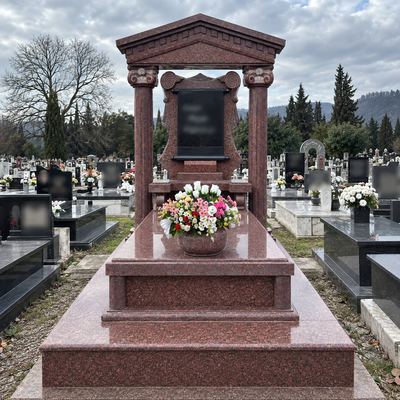 Red granite monument with two columns and a pediment