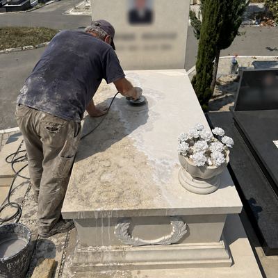 Worker polishing an old marble grave